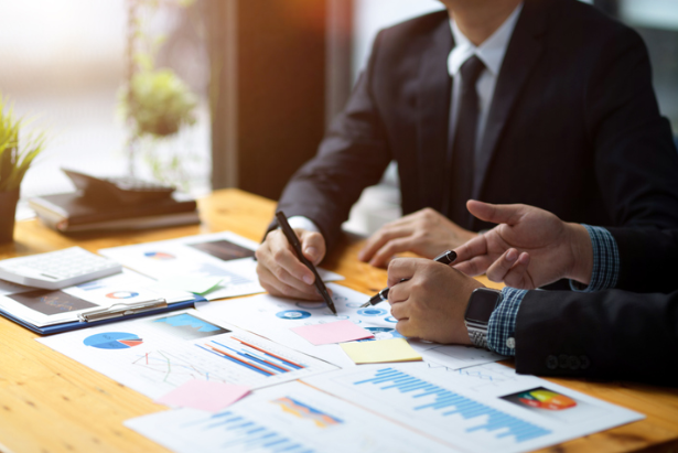 Business professionals reviewing financial charts while planning offshore trust management by First Anguilla Trust